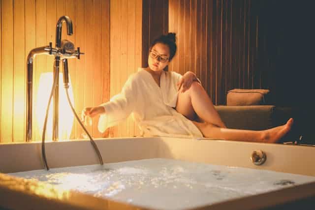 une femme en peignoir qui se fait couler un bain