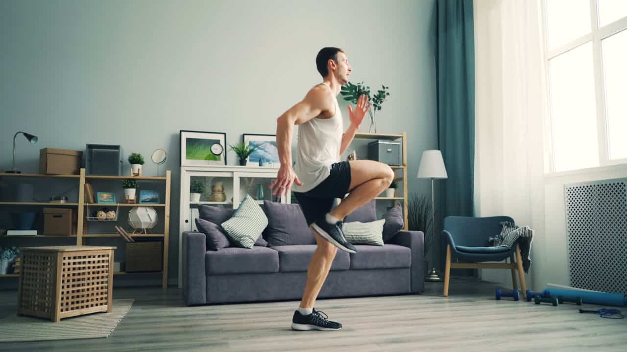 un homme qui fait du sport dans son salon