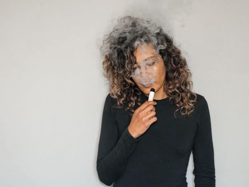 une femme avec une cigarette électronique