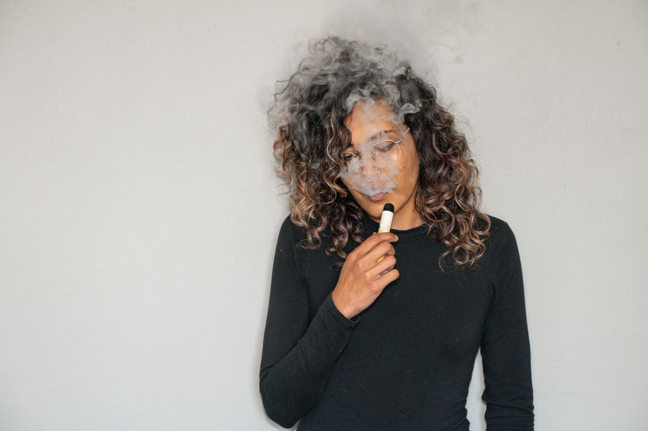 une femme avec une cigarette électronique