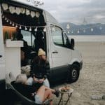 un couple dans un van avec des guirlandes